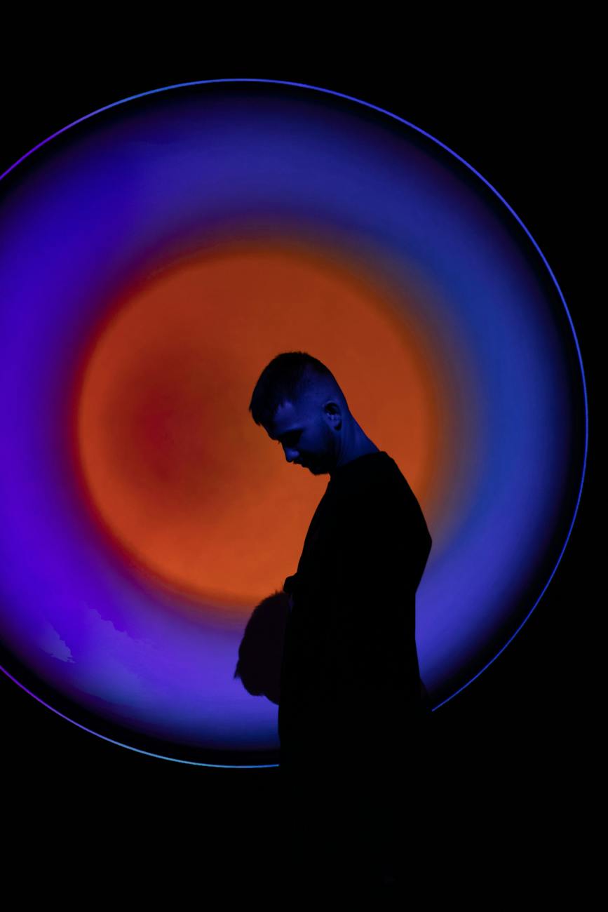 man on the background of a circle from orange and blue light